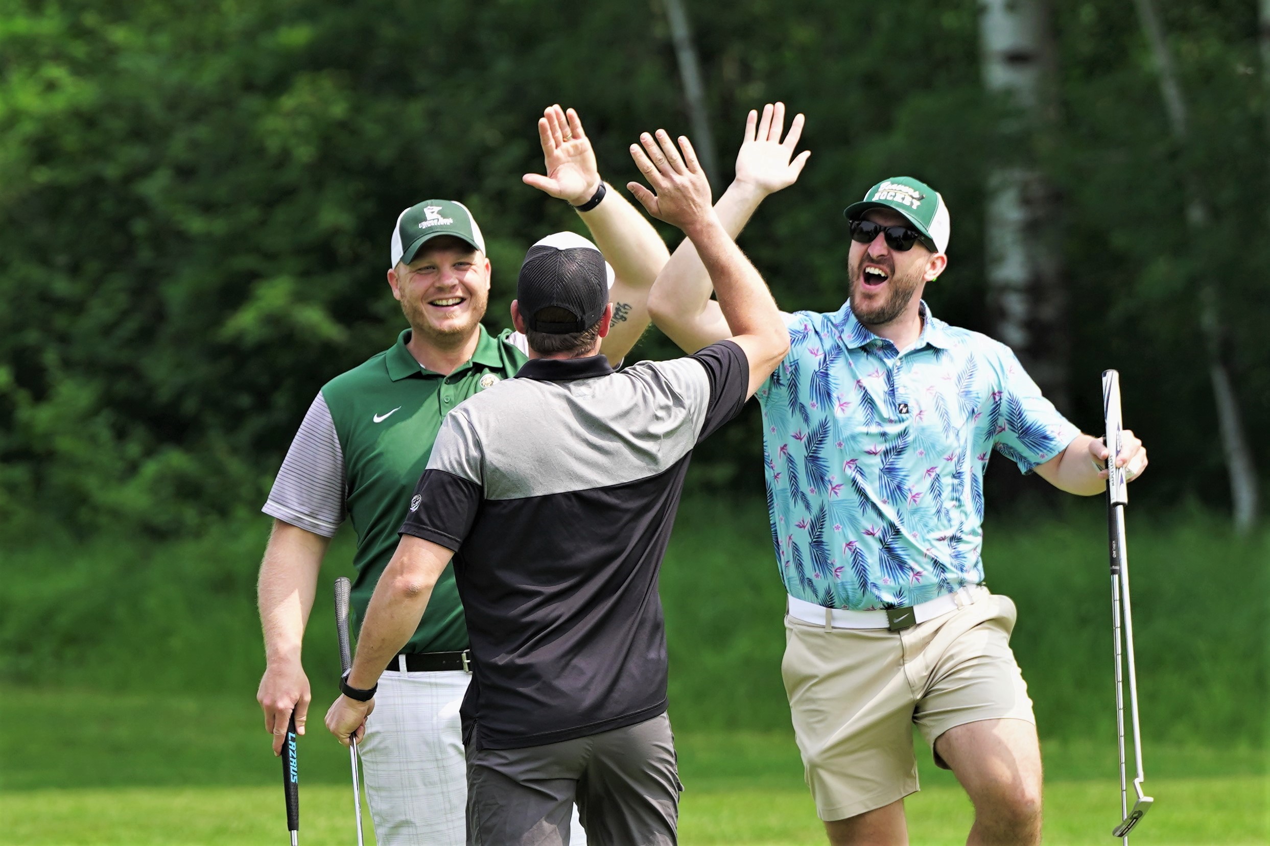 Jordan Anderson, left, Connor Laird, right, and Jake Sobieck celebrate after Anderson sunk a long putt on No. 15 during the 46th annual Gordy Skaar Memorial Golf Tournament on Friday, June 16, 2023, at the Bemidji Town and Country Club. (Micah Friez / Bemidji State)