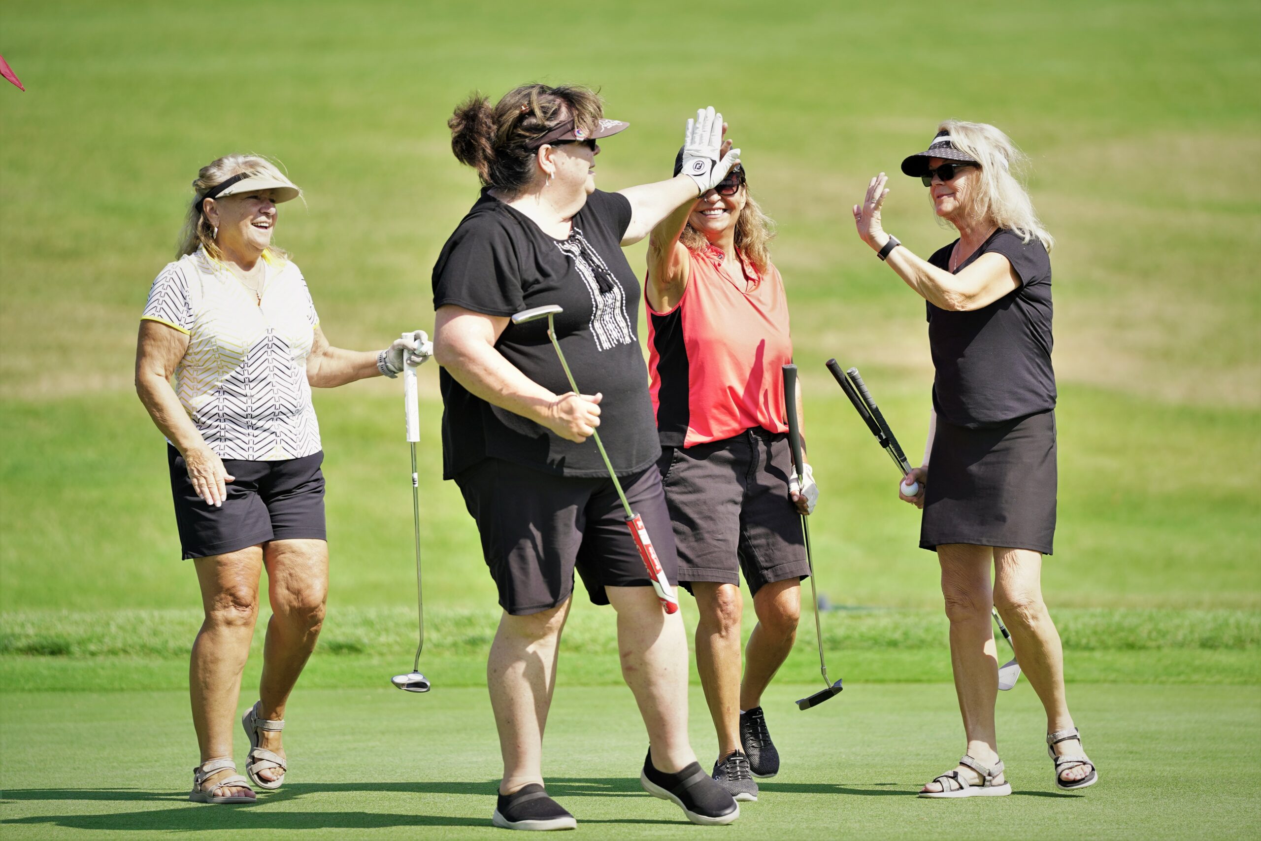 A group celebrates sinking a putt on No. 18 during the Howe-Welle Women's Athletics Golf Tournament on Friday, Aug. 25, 2023, at the Bemidji Town and Country Club. (Micah Friez / Bemidji State)