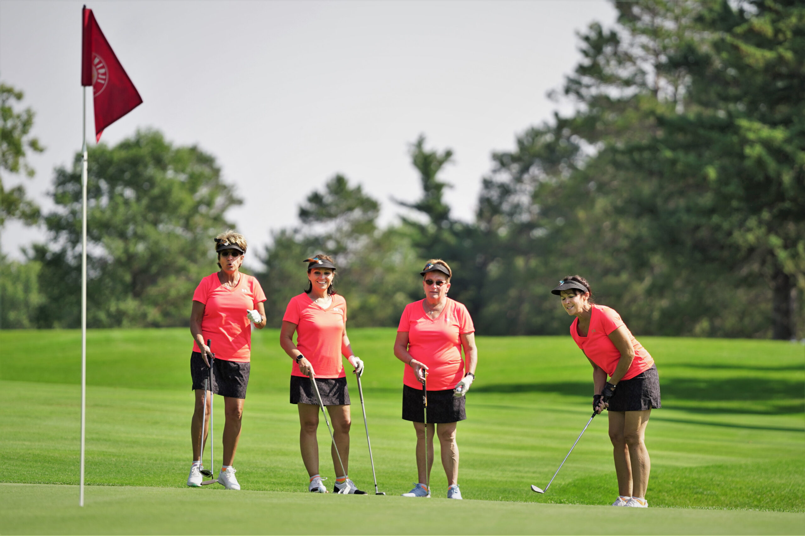 A group watches a putt roll toward the pin on No. 7 during the Howe-Welle Women's Athletics Golf Tournament on Friday, Aug. 25, 2023, at the Bemidji Town and Country Club. (Micah Friez / Bemidji State)