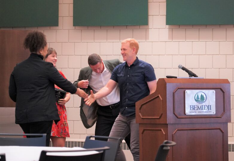 Travis Ricks greeted by foundation members to receive the "Friend of the Foundation" award  at the welcome back breakfast event on Tuesday, Aug. 20, 2024. (Stella Dolan / Bemidji State)