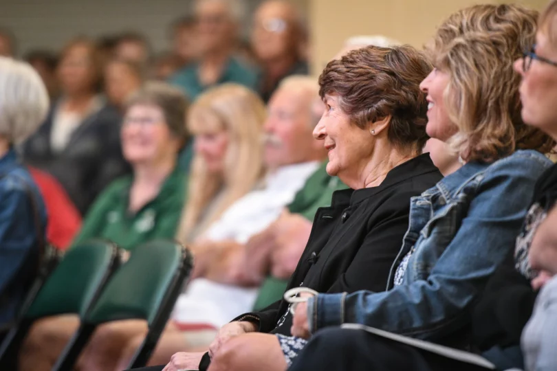 Lou Peters, wife of the late Bemidji State men's hockey coach R.H. "Bob" Peters, listens to a speaker during an unveiling ceremony for a bust of R.H. at the Sanford Center on Thursday, Sept. 12, 2024, in Bemidji.Madelyn Haasken / Bemidji Pioneer