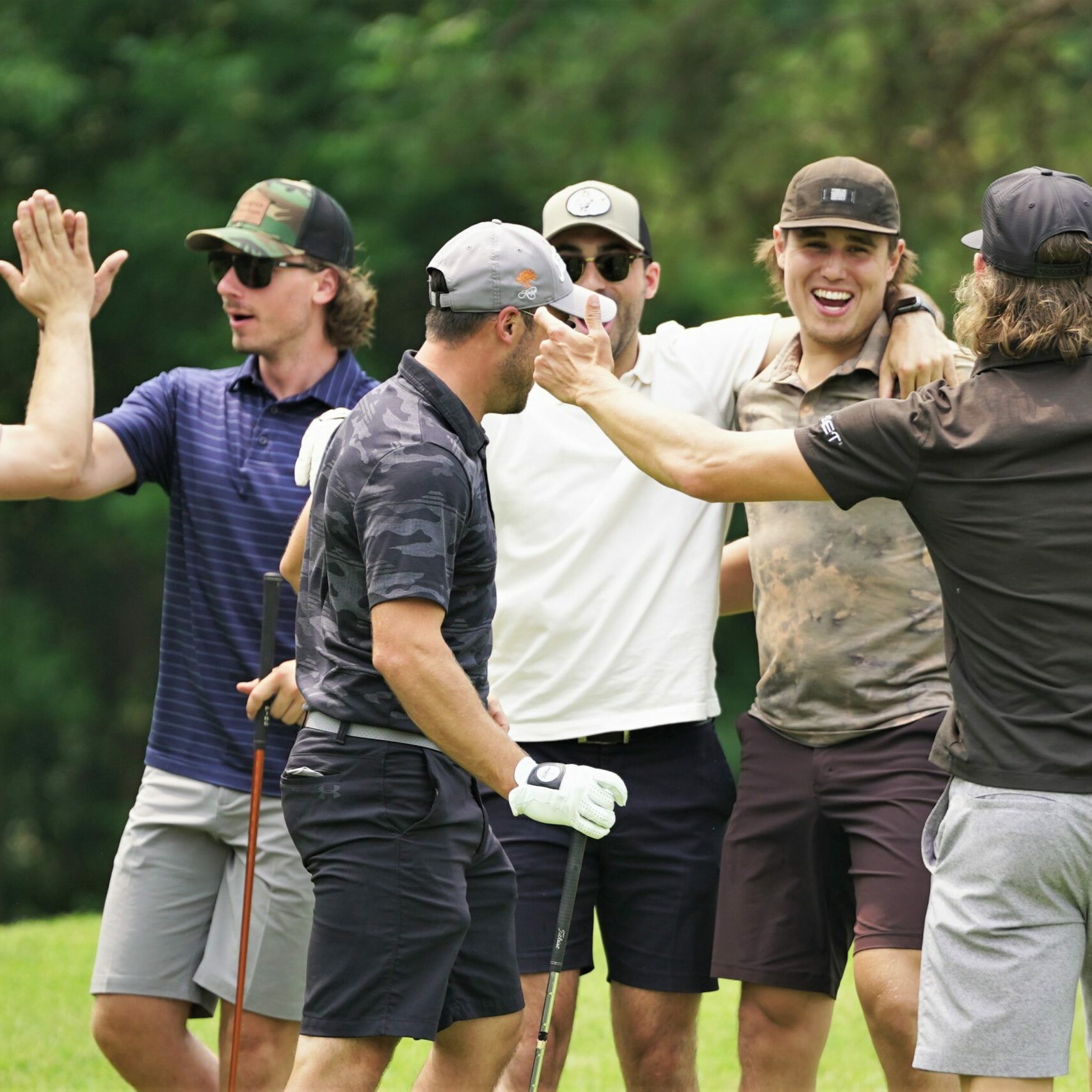 Zach Whitecloud, second from right, is mobbed by his teammates after sinking a long putt on hole No. 2 during the 26th annual Galen Nagle Memorial Golf Tournament on Friday, July 14, 2023, at the Bemidji Town and Country Club. (Micah Friez / Bemidji State)